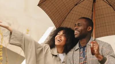 Happy travelers with luggage at airport, protected by comprehensive travel insurance