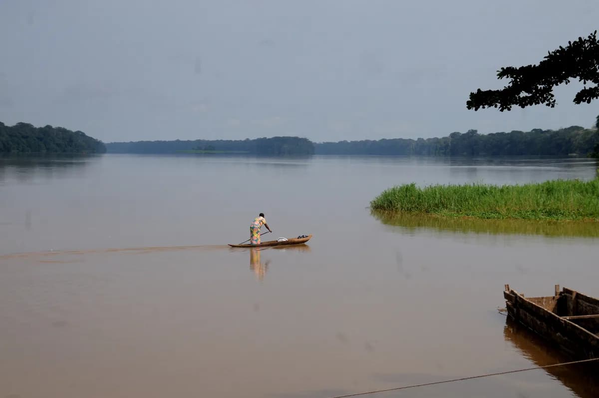 Congo Basin pirogue travel — remote park access routes, riverine forest shorelines, wildlife spotting from the water